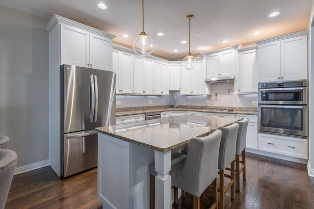 kitchen with white cabinetry, pendant lighting, stainless steel appliances, and dark hardwood / wood-style floors