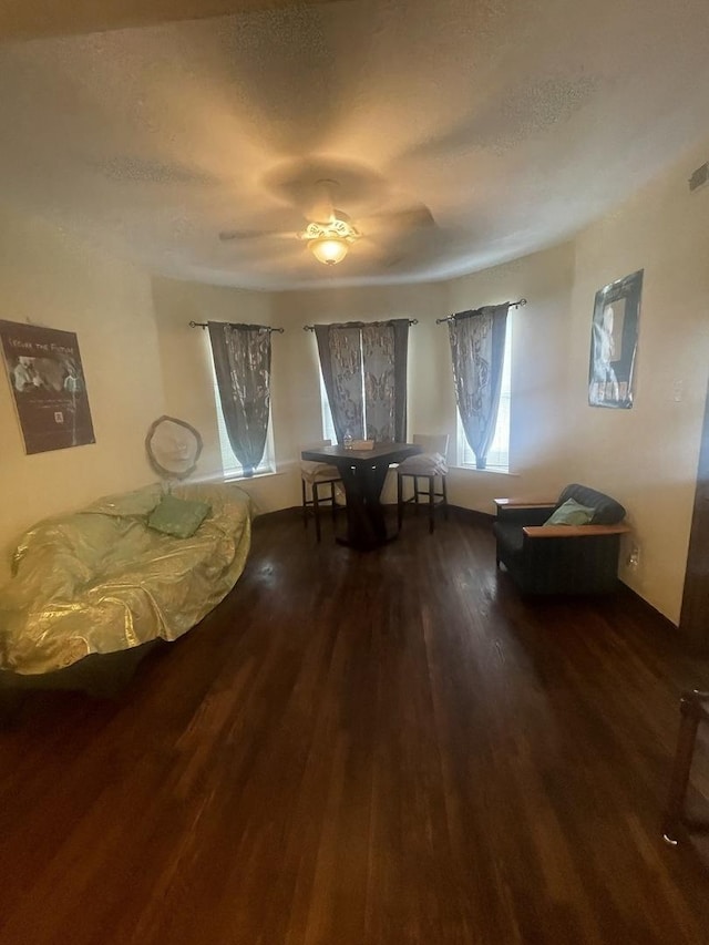 living area with a textured ceiling, ceiling fan, and hardwood / wood-style floors