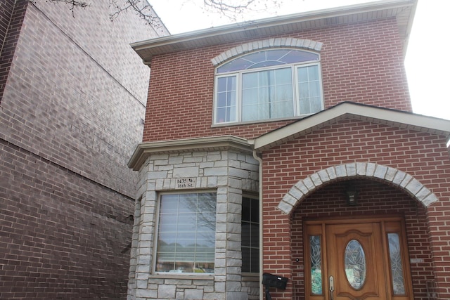 entrance to property with stone siding and brick siding