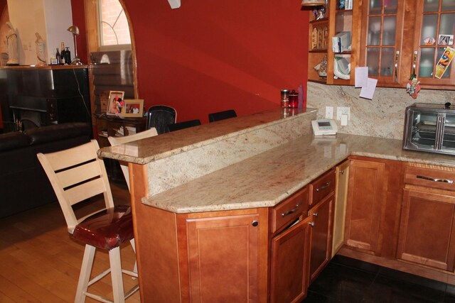 bar with decorative backsplash, a toaster, and dark wood finished floors