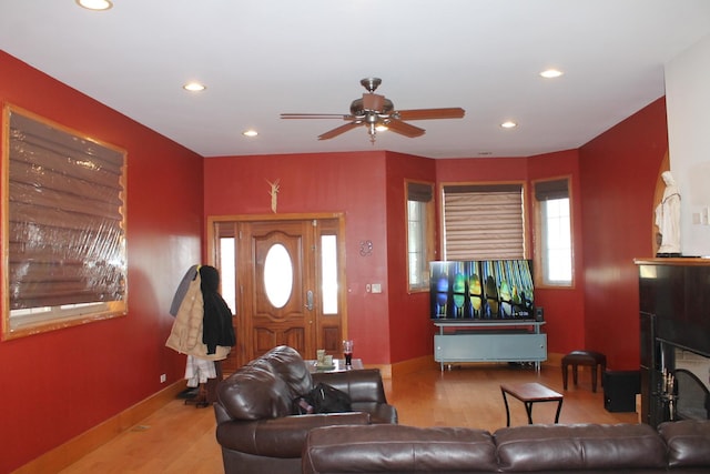 living room with recessed lighting, baseboards, wood finished floors, and a fireplace