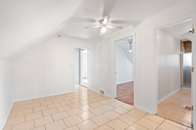 additional living space with ceiling fan, lofted ceiling, and light wood-type flooring