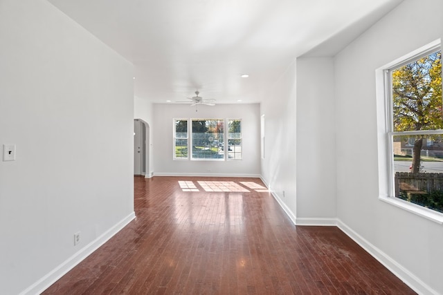 unfurnished living room with ceiling fan and dark wood-type flooring