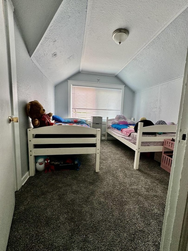 bedroom with vaulted ceiling, carpet floors, and a textured ceiling