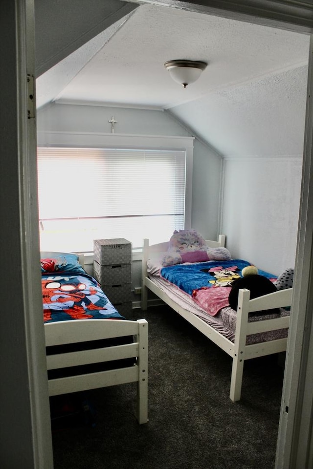 bedroom featuring a textured ceiling, carpet, and lofted ceiling