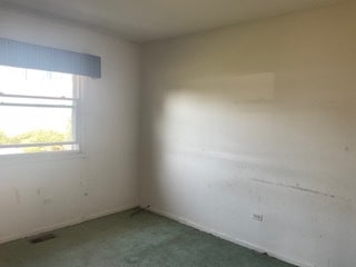 spare room with dark colored carpet