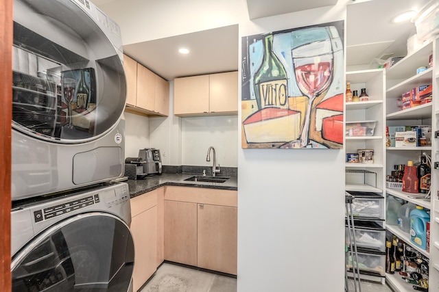 laundry room with stacked washer and clothes dryer and sink