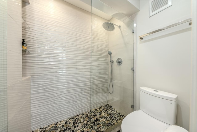 bathroom with tiled shower and toilet