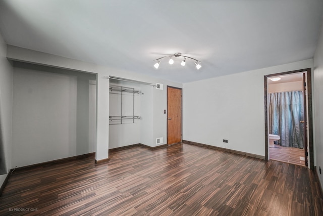 unfurnished bedroom with connected bathroom and dark hardwood / wood-style flooring