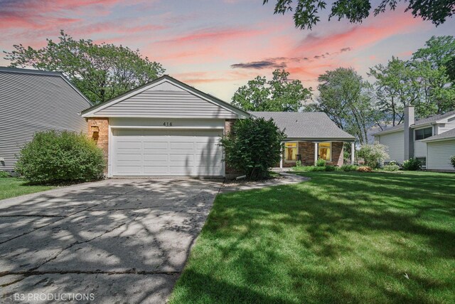 ranch-style home with a lawn and a garage