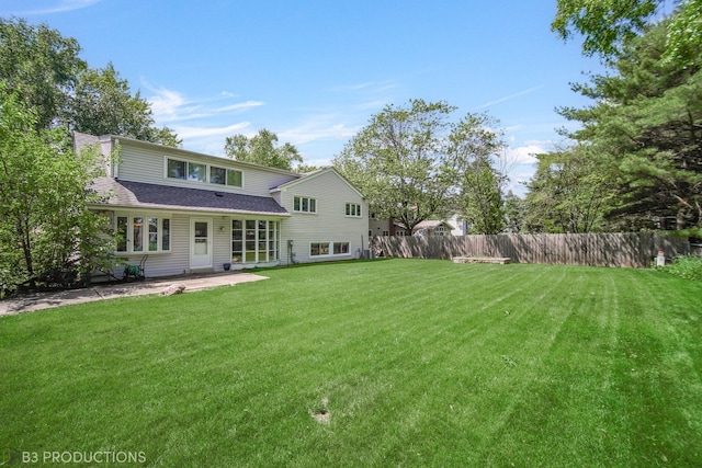 rear view of property featuring a yard and a patio