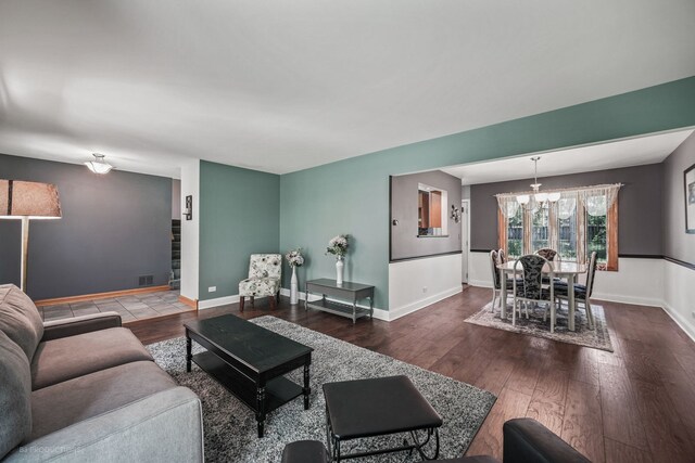 living room featuring wood-type flooring and an inviting chandelier