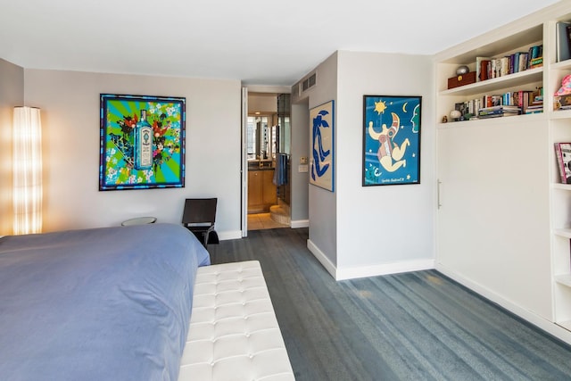 bedroom featuring dark wood-type flooring, visible vents, ensuite bath, and baseboards