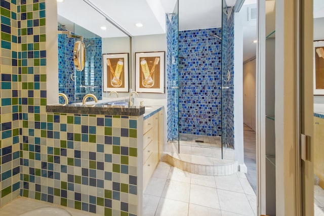 bathroom featuring tile patterned flooring, vanity, visible vents, a spacious closet, and a shower stall