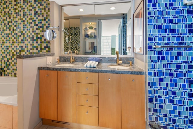 full bathroom with double vanity, a shower stall, and a sink