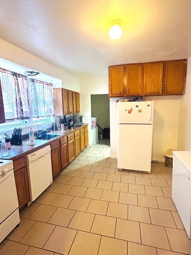 kitchen featuring sink, white appliances, and light tile patterned flooring