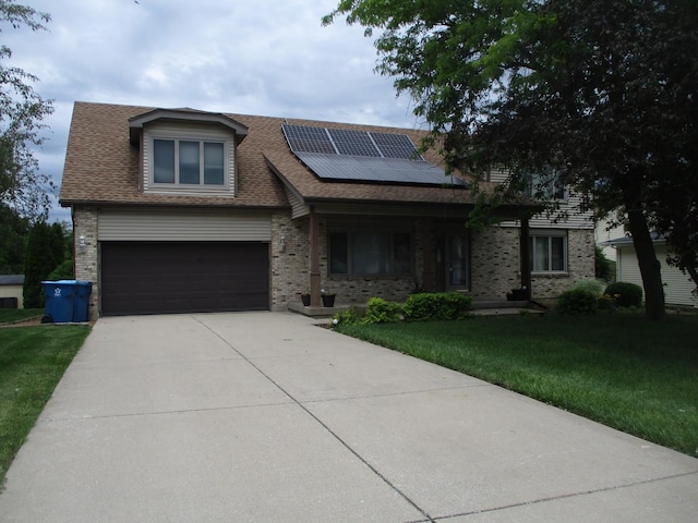 view of front of property featuring solar panels, a shingled roof, an attached garage, a front yard, and driveway