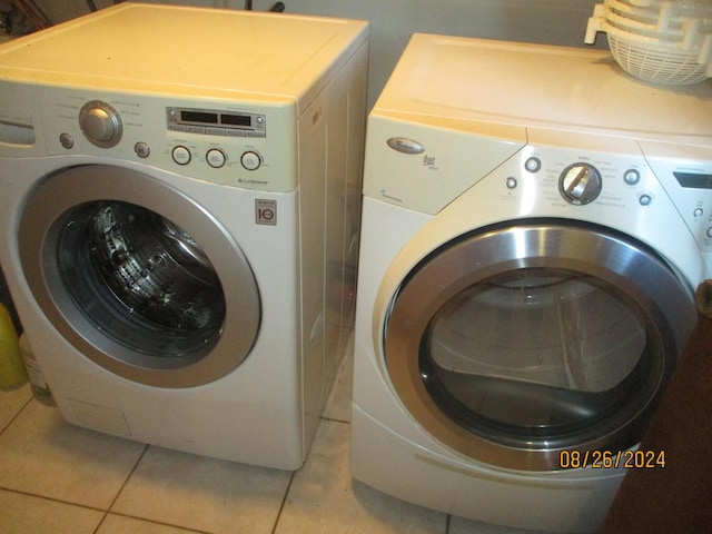 laundry room featuring washer and dryer and light tile patterned floors