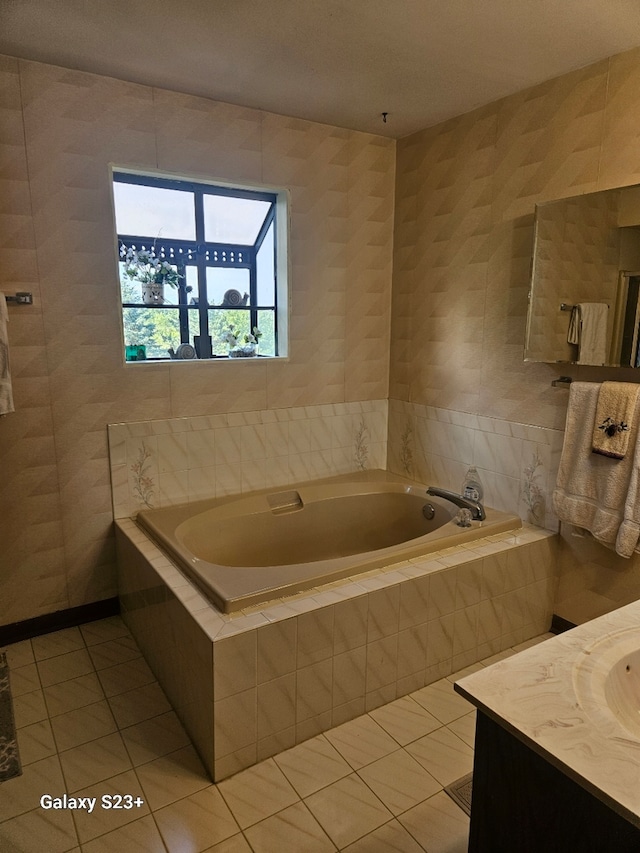 full bathroom featuring tile walls, a garden tub, vanity, and tile patterned floors