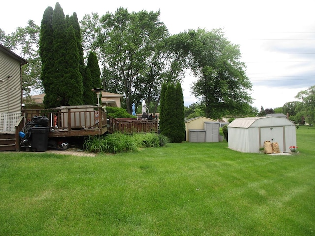 view of yard featuring an outbuilding, a wooden deck, and a storage unit