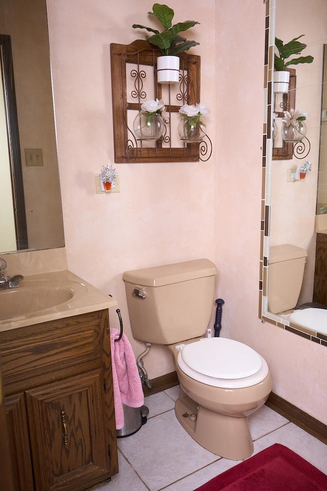 bathroom featuring vanity, tile patterned flooring, toilet, and baseboards