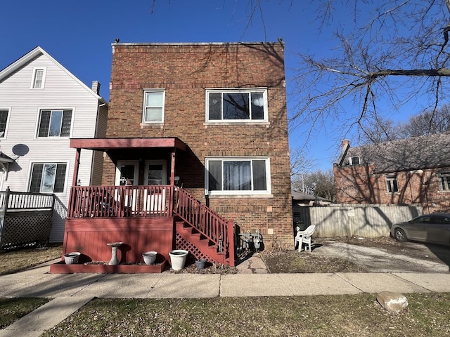 view of front facade featuring a wooden deck and brick siding