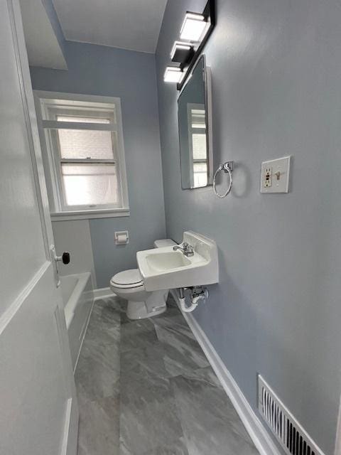 bathroom featuring visible vents, baseboards, toilet, a bathtub, and marble finish floor