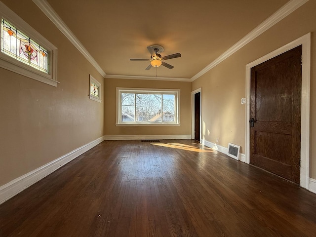 spare room with visible vents, baseboards, ornamental molding, and dark wood finished floors