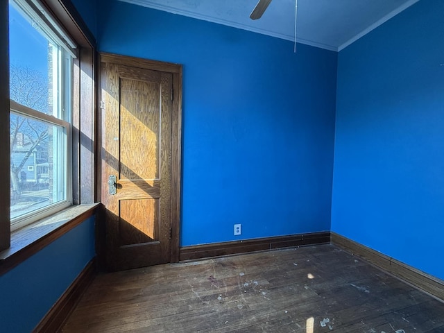 unfurnished room with wood finished floors, a ceiling fan, baseboards, and ornamental molding