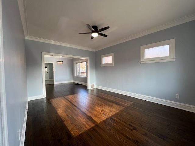 empty room with ceiling fan with notable chandelier, crown molding, and dark wood-type flooring