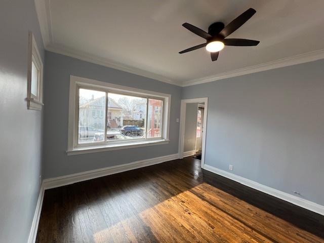 unfurnished room with dark wood-type flooring, ceiling fan, and crown molding