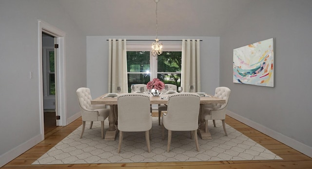 dining space featuring light hardwood / wood-style flooring, a chandelier, and lofted ceiling