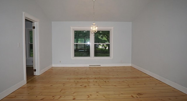 unfurnished dining area featuring lofted ceiling, light wood-type flooring, and an inviting chandelier