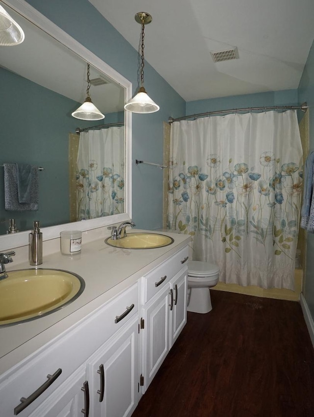 bathroom featuring wood-type flooring, vanity, toilet, and walk in shower