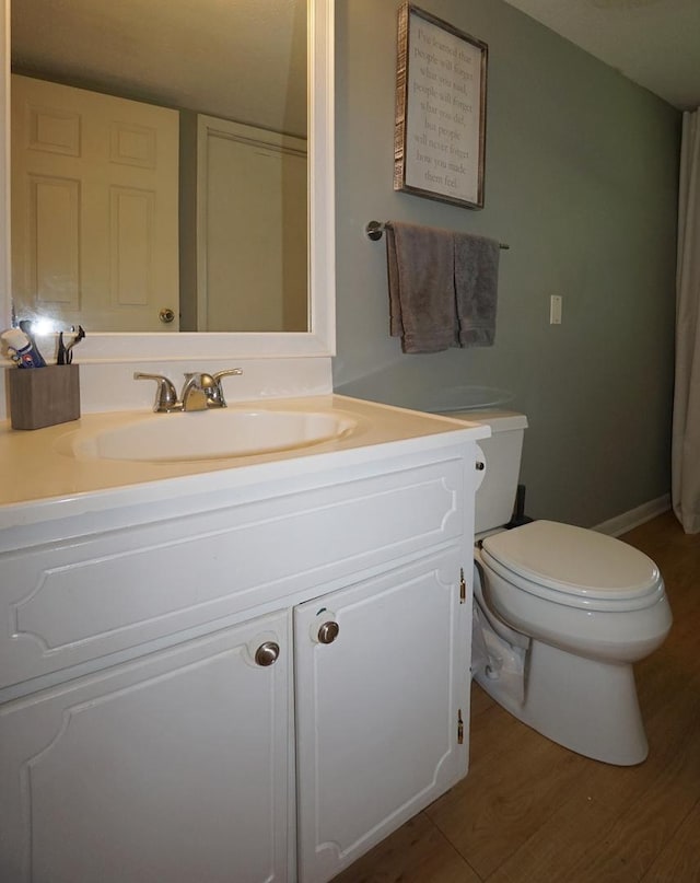 bathroom with vanity, hardwood / wood-style flooring, and toilet