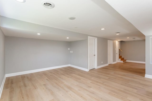 finished below grade area featuring recessed lighting, stairway, light wood finished floors, and baseboards