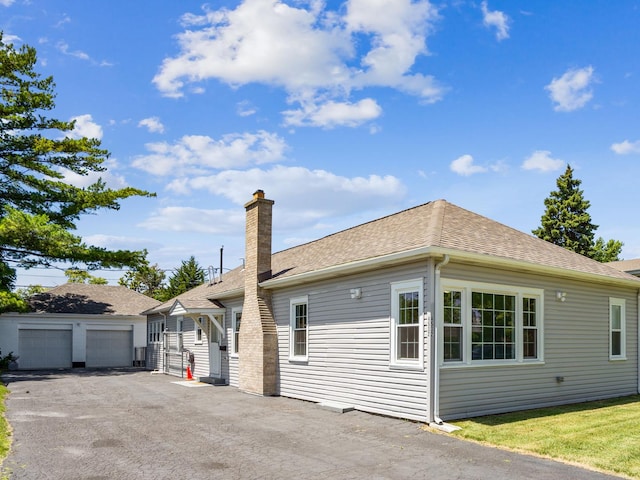 view of front of home with a garage and an outbuilding