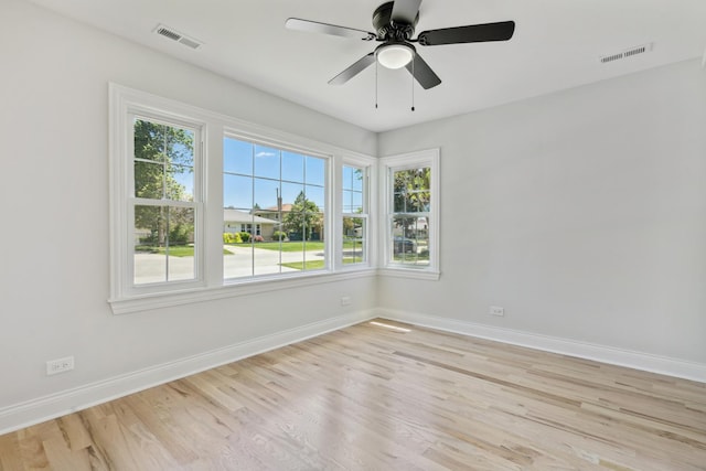 spare room with ceiling fan, light hardwood / wood-style flooring, and a healthy amount of sunlight