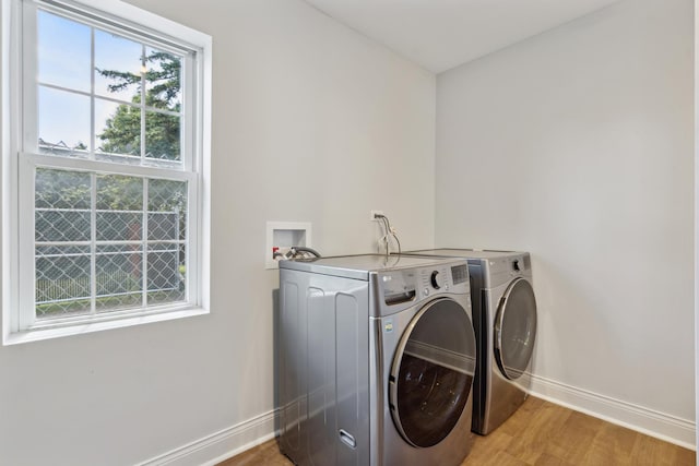 washroom with light hardwood / wood-style floors and washing machine and clothes dryer