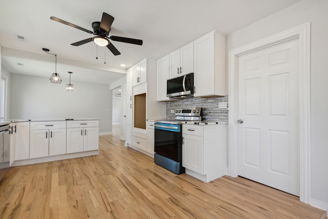 kitchen featuring white cabinetry, ceiling fan, tasteful backsplash, light hardwood / wood-style flooring, and appliances with stainless steel finishes