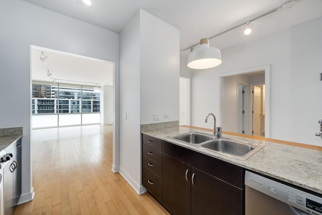 kitchen with dark brown cabinetry, sink, a wall of windows, stainless steel dishwasher, and pendant lighting