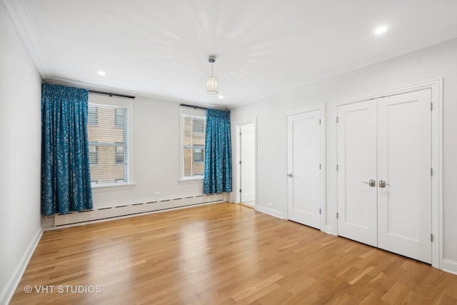 unfurnished bedroom with crown molding, two closets, light hardwood / wood-style flooring, and a baseboard radiator