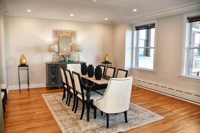 dining room featuring light hardwood / wood-style floors, a baseboard heating unit, and ornamental molding