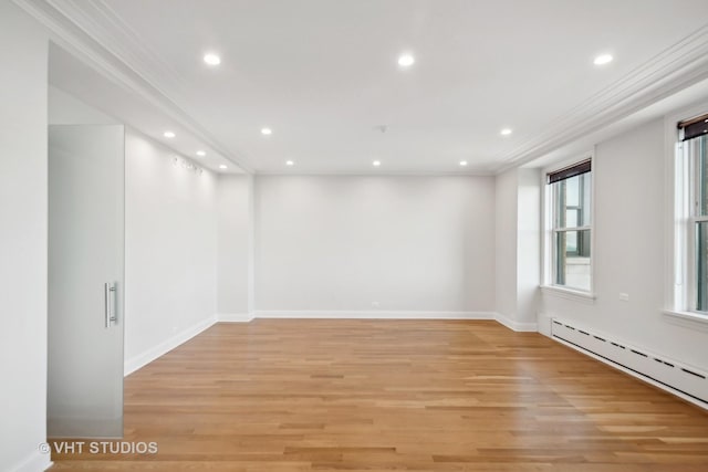 empty room with a baseboard heating unit, crown molding, and light hardwood / wood-style floors