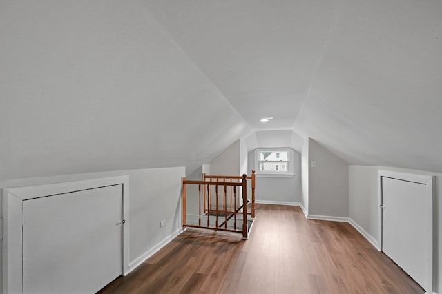 additional living space featuring hardwood / wood-style flooring and vaulted ceiling