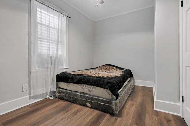 bedroom featuring ceiling fan, crown molding, and dark hardwood / wood-style flooring