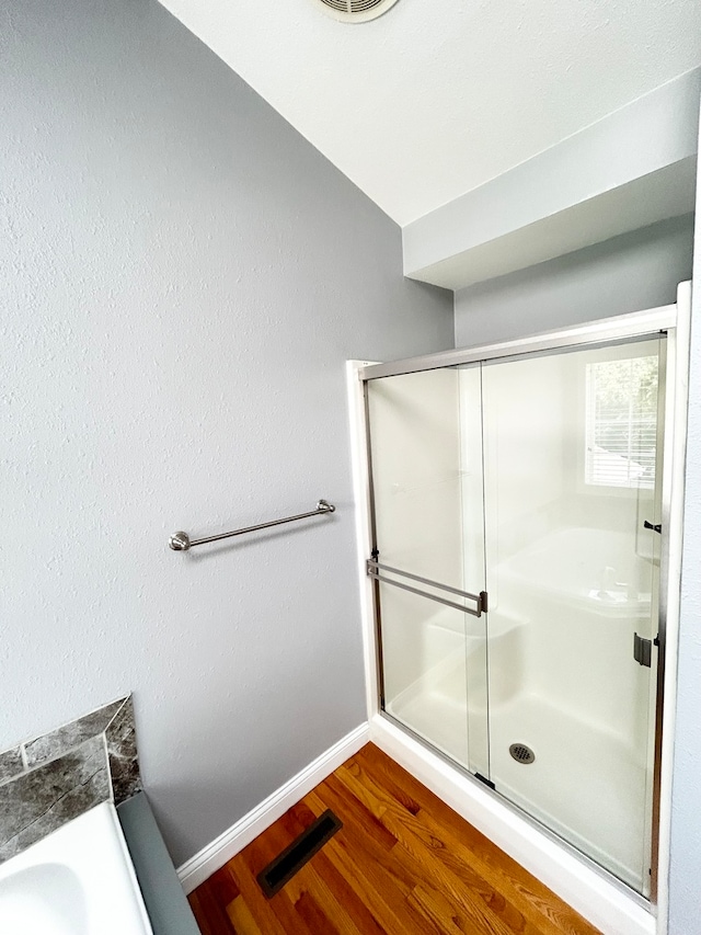 full bath featuring visible vents, a shower stall, baseboards, and wood finished floors