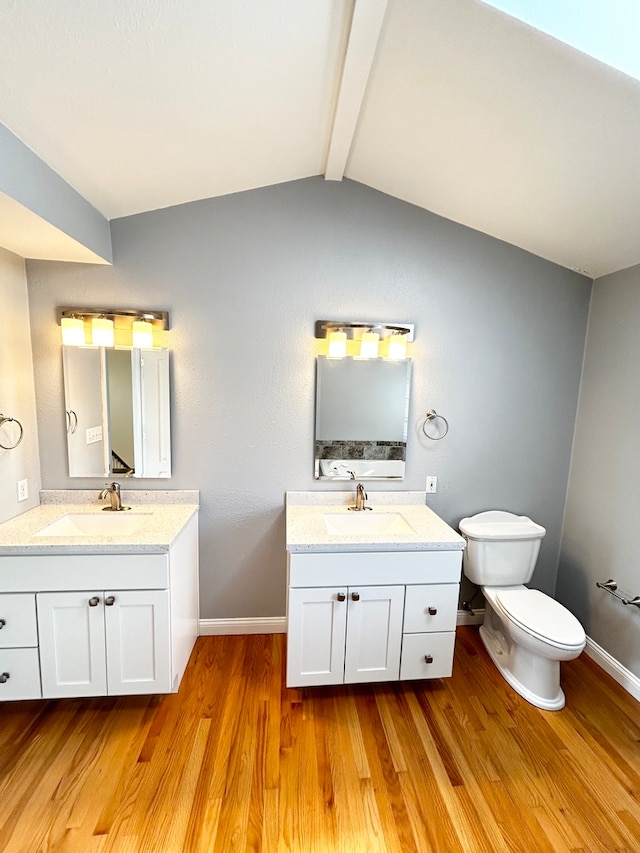 bathroom with vaulted ceiling with beams, a sink, baseboards, and wood finished floors