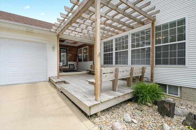 wooden deck featuring a garage and a pergola