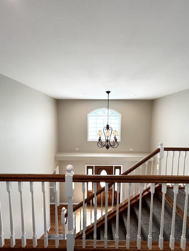 stairs featuring an inviting chandelier